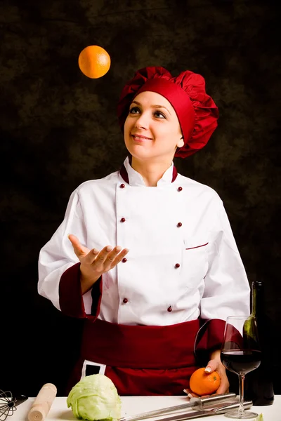 Chef juggling with orange — Stock Photo, Image
