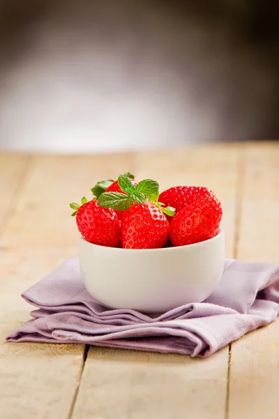 草莓与紫餐巾的木桌上 — 图库照片