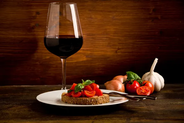 Bruschetta előétel a vörös bor, a fából készült asztal — Stock Fotó