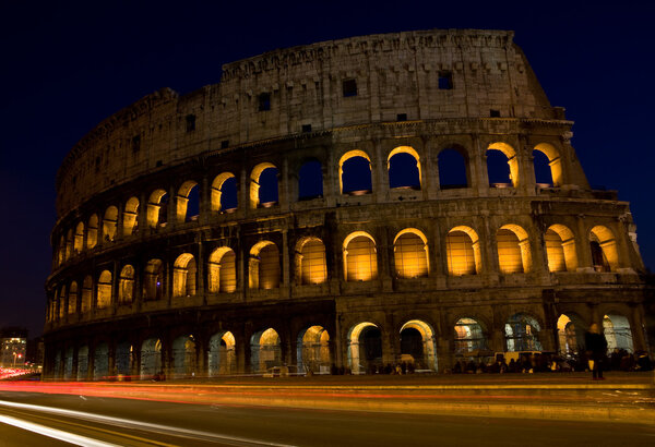 Photo of the roman colosseum taken by night with dark blue sky