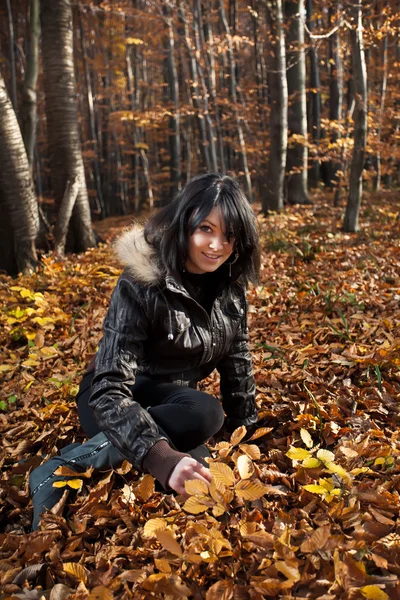 Молода жінка сидить на осінньому лісі — стокове фото