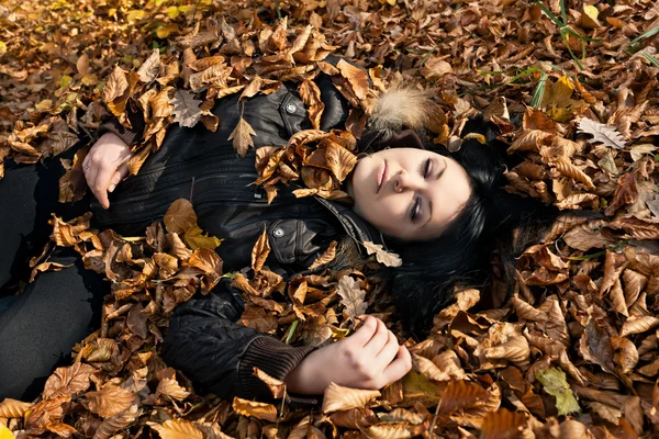 Mulher deitada em folhas caídas — Fotografia de Stock