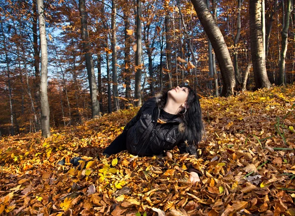 Kobieta, leżąc w opadłych liści — Zdjęcie stockowe