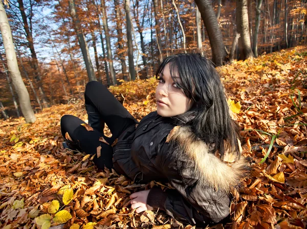 Donna sdraiata in foglie cadute — Foto Stock