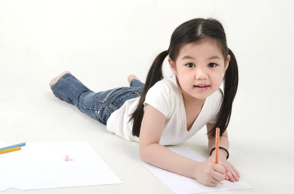 Kleine asiatische Mädchen zeichnen, auf dem Boden liegend — Stockfoto