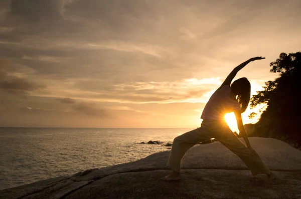 Asyalı kız kumsalda Yoga gerçekleştirme — Stok fotoğraf