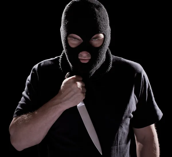 Ladrón en mascarilla sosteniendo cuchillo — Foto de Stock