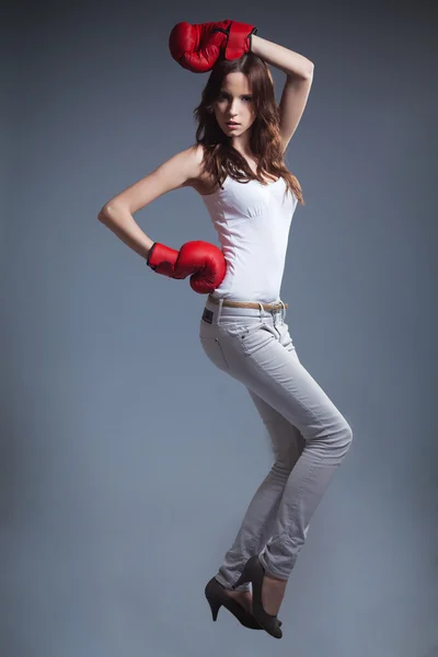 Young slim sexy woman boxing red gloves posing