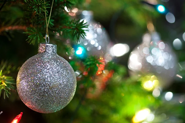 Ornamento de Natal com árvore iluminada no fundo, espaço de cópia — Fotografia de Stock