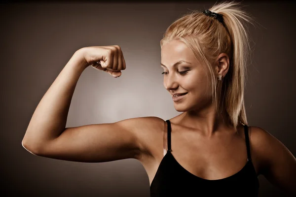 Kvinna flexar sin biceps — Stockfoto