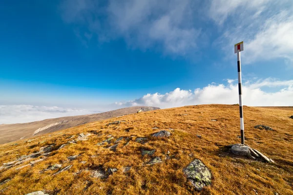 Pole marking route in mountains — Stock Photo, Image