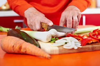 Senior woman's hands cutting vegetables clipart