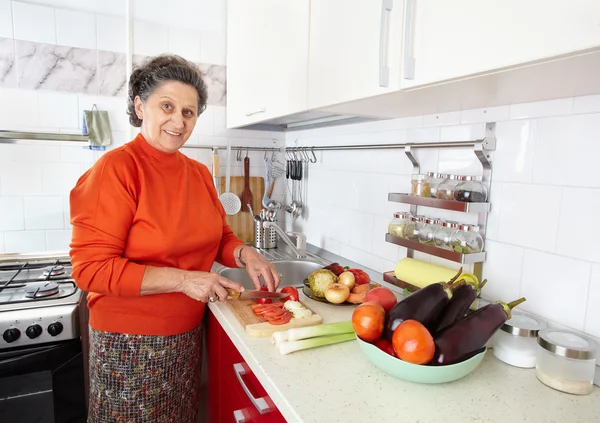 Ηλικιωμένη γυναίκα στην κουζίνα. — Φωτογραφία Αρχείου