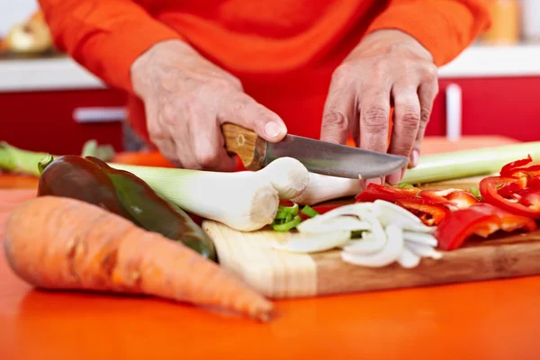 Las manos de la mujer mayor cortar verduras — Foto de Stock