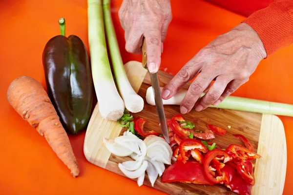 Las manos de la mujer mayor cortar verduras —  Fotos de Stock