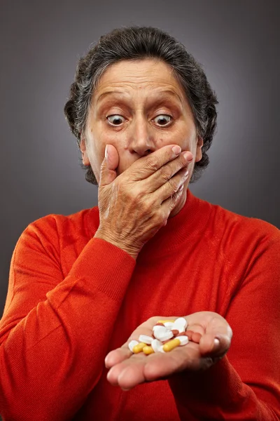 Старшая женщина с слишком большим количеством таблеток — стоковое фото