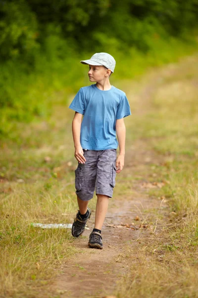 Rapaz a caminhar numa floresta — Fotografia de Stock