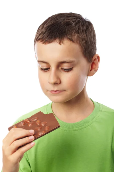 Хлопчик їсть шоколад з мигдалем — стокове фото