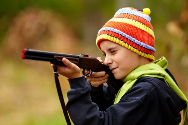 Chłopiec bawi się zabawkami strzelby — Zdjęcie stockowe