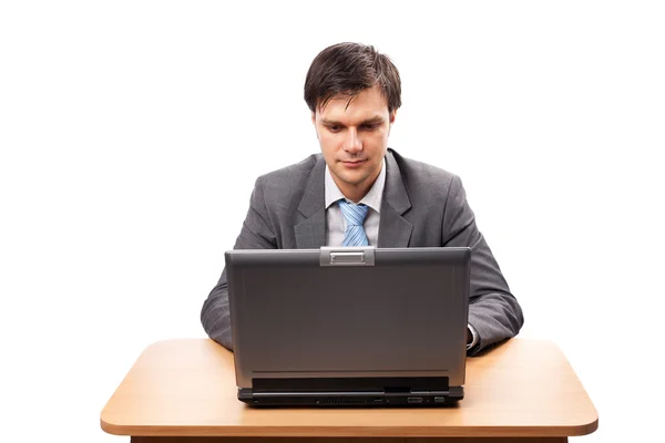 Молодой бизнесмен с ноутбуком за столом — стоковое фото