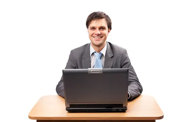 Jovem empresário com laptop em sua mesa — Fotografia de Stock