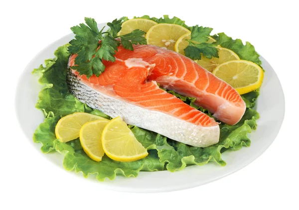 Стейки из красной рыбы с лимоном и петрушкой в тарелке — стоковое фото