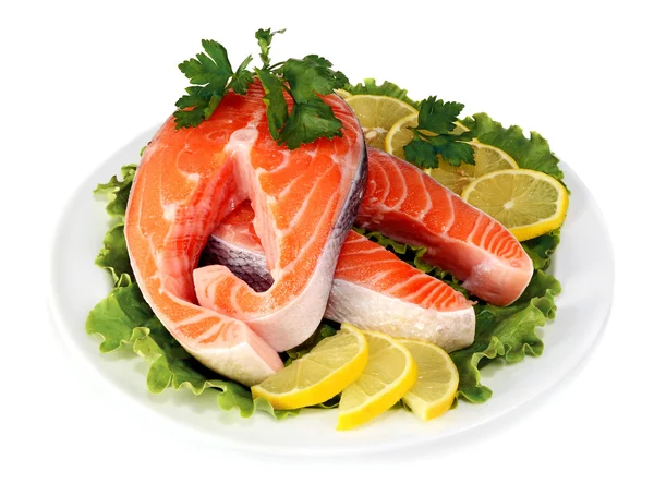 Bifes de peixe vermelho com um limão e salsa em prato — Fotografia de Stock