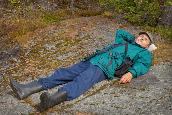Літній турист відпочиває на скелі — стокове фото
