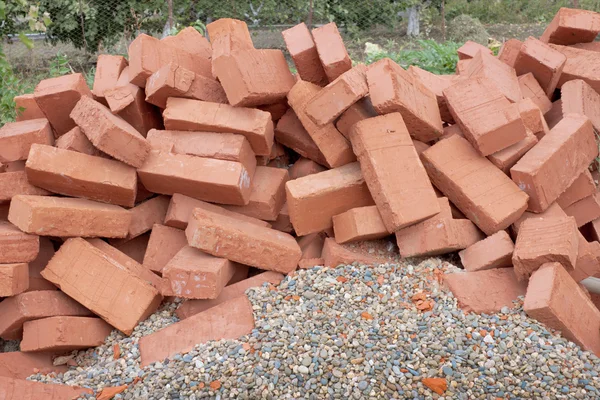 Red clay bricks lying on the gravel — Stock Photo, Image