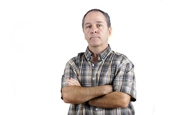 Middle aged caucasian man with doubtful expresssion and arms crossed looking at camera over white background.