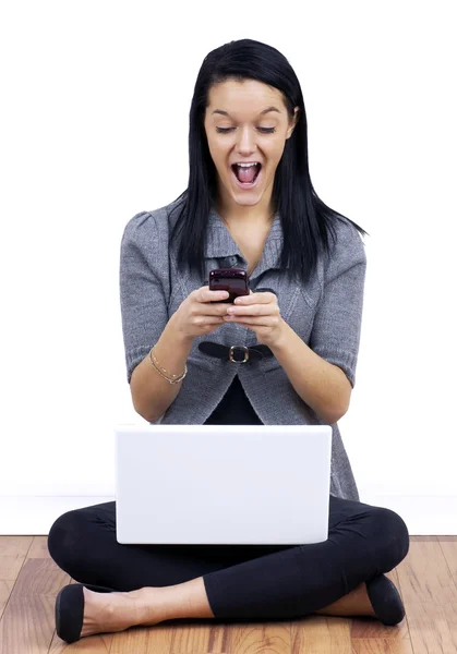 Jonge vrouw texting met laptop op gekruiste benen — Stockfoto