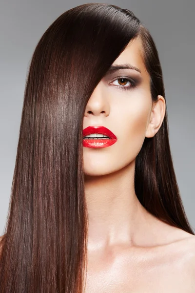 Kvinna modell med röda läppar. mode frisyr med mjuka länge kvinnliga hår — Stockfoto