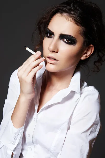 Belle femme modèle fumant une cigarette. Maquillage rock foncé — Photo