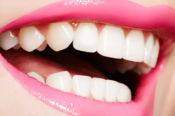 Makro glad kvinnans leende med friska vita tänder, ljust läppglans läppar Stockbild