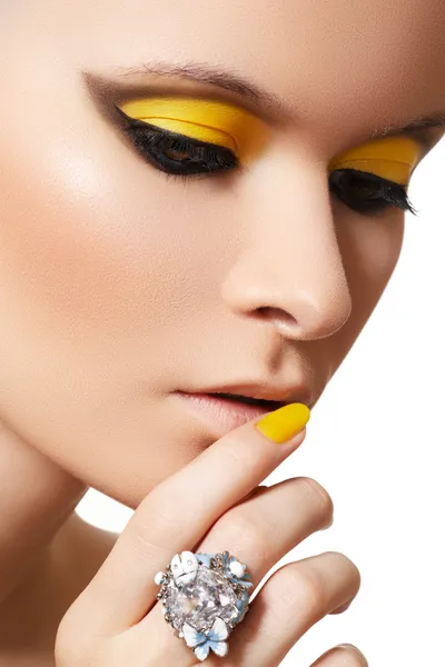 Ritratto ravvicinato di bel viso modello con trucco giallo brillante al neon — Foto Stock