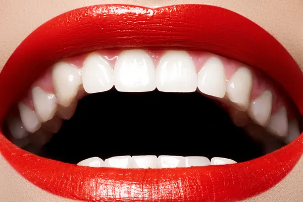 Sonrisa femenina feliz de cerca con dientes blancos sanos, labios brillantes de color rojo brillante —  Fotos de Stock