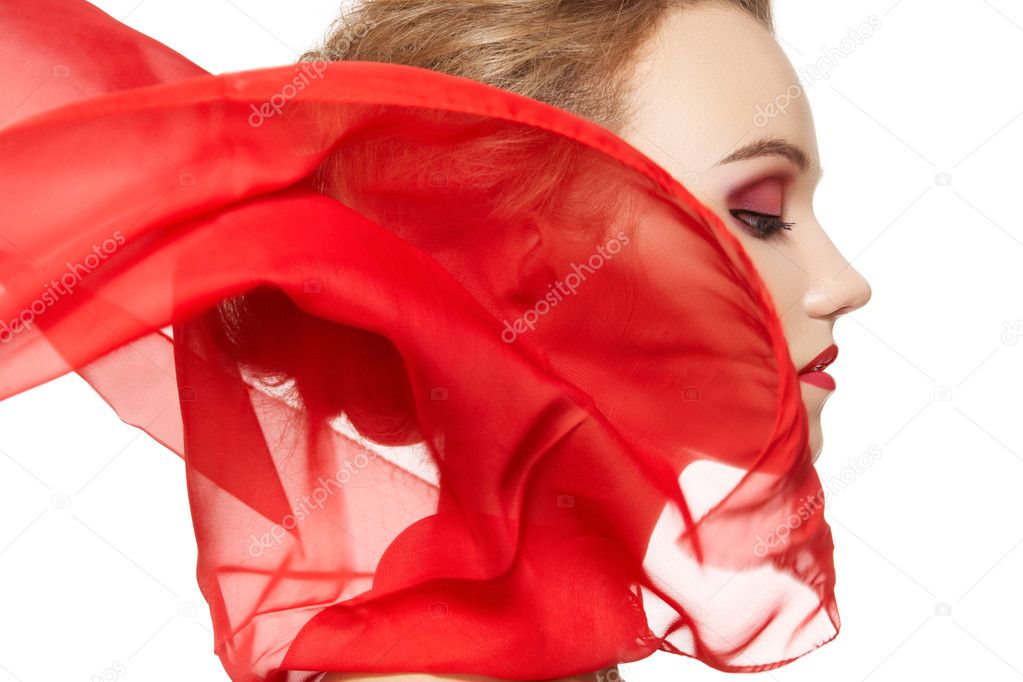Fashionable portrait of a girl model with waving red silk scarf
