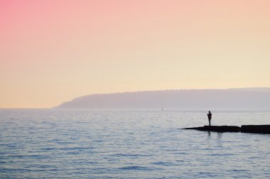 Silhouette of a fisherman clipart