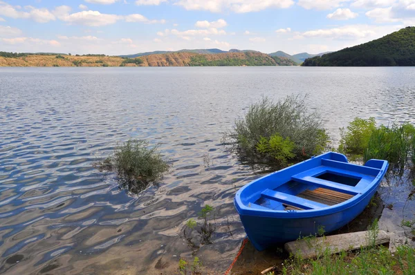 Одиночная лодка на берегу озера — стоковое фото