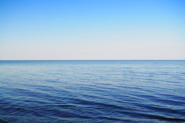 Calm sea and clowdless sky clipart