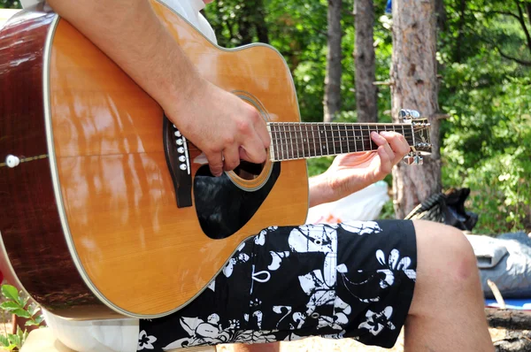 Young man playing acoustic guitar in the nature — Stock Photo, Image