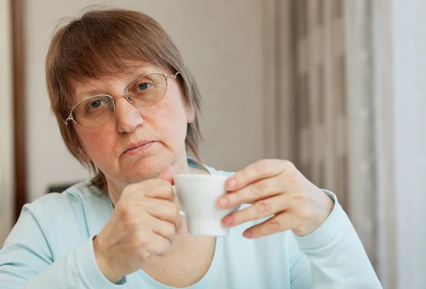 Ηλικιωμένη γυναίκα με ένα φλιτζάνι καφέ — Φωτογραφία Αρχείου