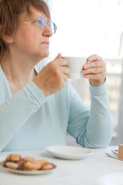 Mulher tomando café com biscoitos — Fotografia de Stock