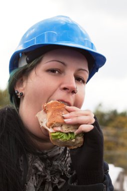 Female worker eating sandwich clipart