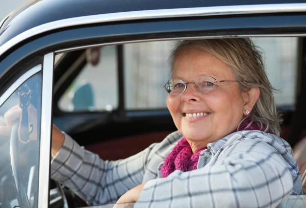 Senior woman in oldtimer car — Stock Photo, Image