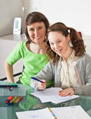 Girl doing homework with her mom clipart