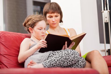 Mother and daughter reading book together clipart