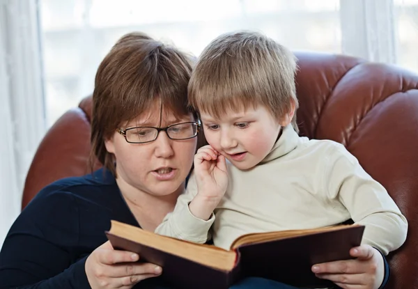 Мальчик и его мама вместе читают книгу — стоковое фото