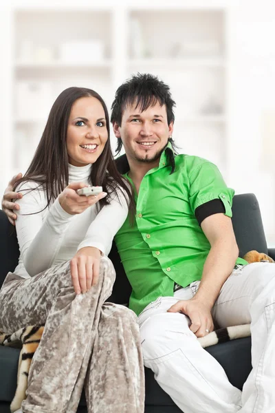 Smiling couple watches TV — Stok fotoğraf
