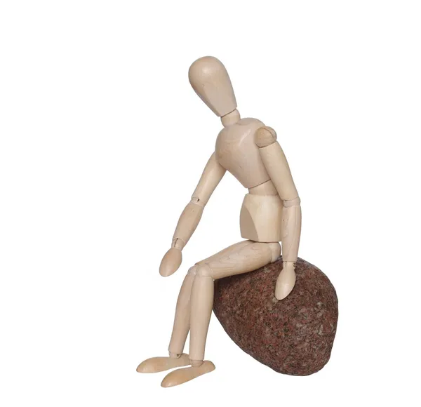 Sitting on stone wooden dummy — Stock Photo, Image